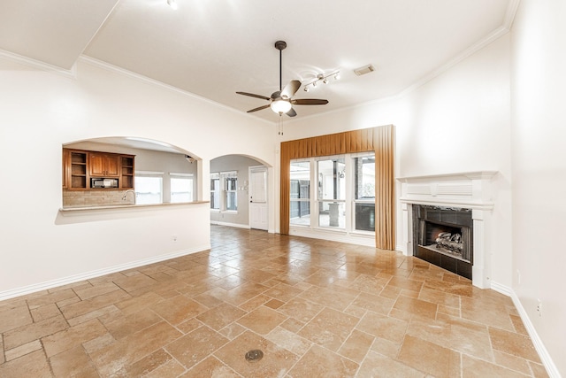 12515 Country Arbor Ln, Houston, TX 77041 - unfurnished living room with a ceiling fan, crown molding, stone tile flooring, a tile fireplace, and baseboards