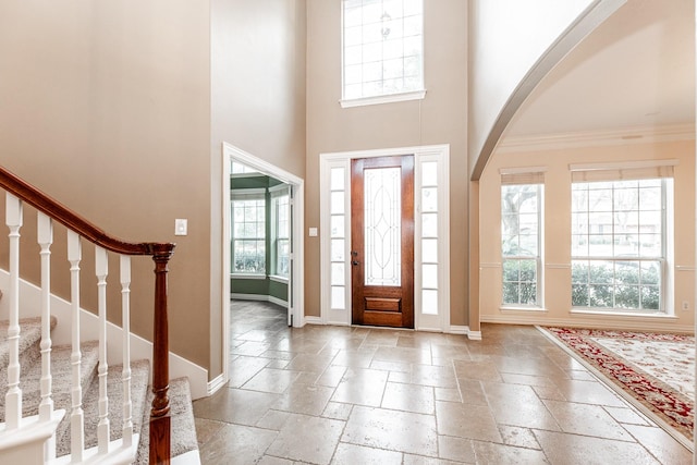 12515 Country Arbor Ln, Houston, TX 77041 - entrance foyer featuring stone tile flooring, baseboards, arched walkways, a towering ceiling, and ornamental molding