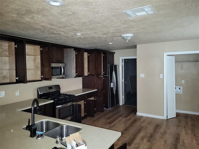 3231 S Greenpark Dr, Houston, TX 77082 - kitchen featuring stainless steel appliances, a sink, light countertops, dark wood-style flooring, and dark brown cabinetry