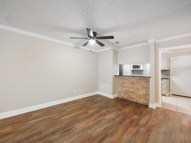 6402 Del Monte Dr Unit 20, Houston, TX 77057 - unfurnished living room featuring wood finished floors, ceiling fan, a textured ceiling, baseboards, and ornamental molding