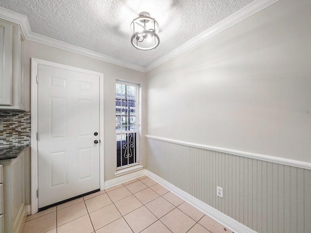 6402 Del Monte Dr Unit 20, Houston, TX 77057 - foyer with a textured ceiling, light tile patterned floors, a wainscoted wall, and crown molding