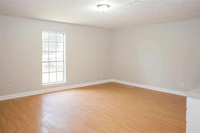 912 Robinson Rd, La Porte, TX 77571 - unfurnished room featuring light wood-style floors, baseboards, and a textured ceiling