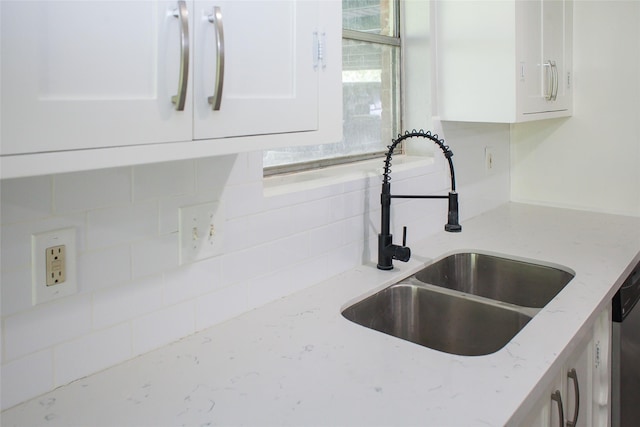 912 Robinson Rd, La Porte, TX 77571 - kitchen view of a sink, white cabinets, tasteful backsplash, and light stone countertops