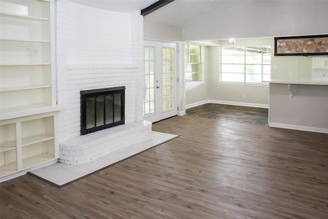 912 Robinson Rd, La Porte, TX 77571 - unfurnished living room with a fireplace, vaulted ceiling, wood finished floors, baseboards, and built in shelves