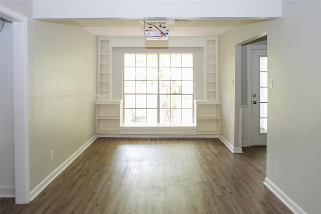912 Robinson Rd, La Porte, TX 77571 - unfurnished dining area featuring dark wood-style flooring, baseboards, and built in features