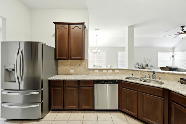 22210 Pacific Ocean Dr, Spring, TX 77388 - kitchen with stainless steel appliances, a sink, light stone countertops, and plenty of natural light