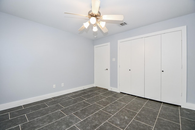 8642 Meadowcroft Dr, Houston, TX 77063 - unfurnished bedroom featuring a closet, dark tile patterned floors, a ceiling fan, and baseboards