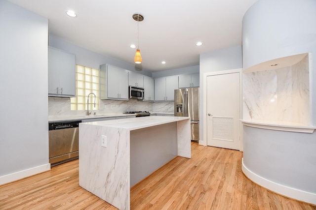 8642 Meadowcroft Dr, Houston, TX 77063 - kitchen with appliances with stainless steel finishes, a sink, a center island, light countertops, and backsplash