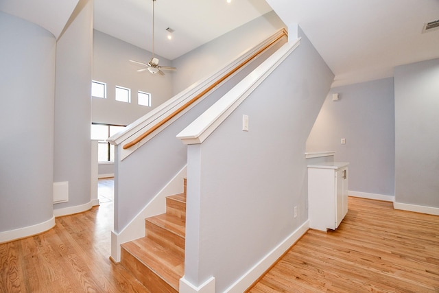 8642 Meadowcroft Dr, Houston, TX 77063 - staircase featuring wood finished floors, baseboards, a ceiling fan, and a high ceiling