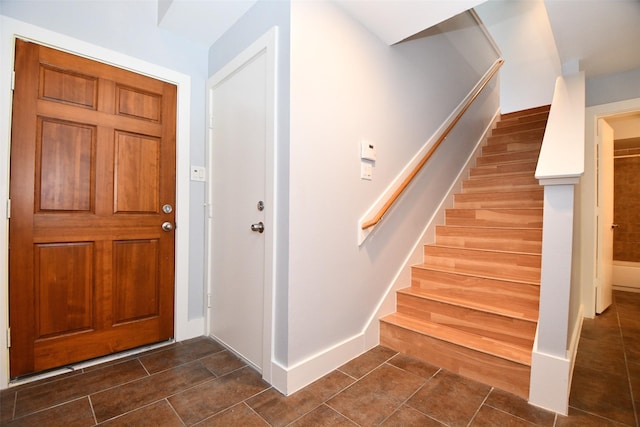 8642 Meadowcroft Dr, Houston, TX 77063 - entryway featuring stairway, dark tile patterned floors, and baseboards