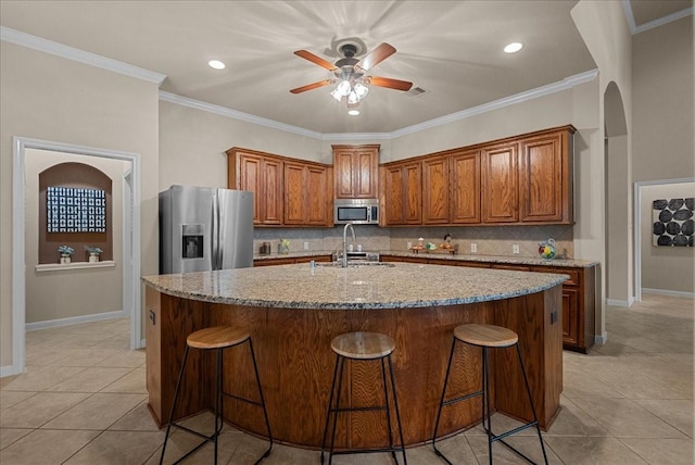 2512 Garnetfield Ln, Friendswood, TX 77546 - kitchen featuring stainless steel appliances, ceiling fan, light tile patterned floors, tasteful backsplash, and ornamental molding