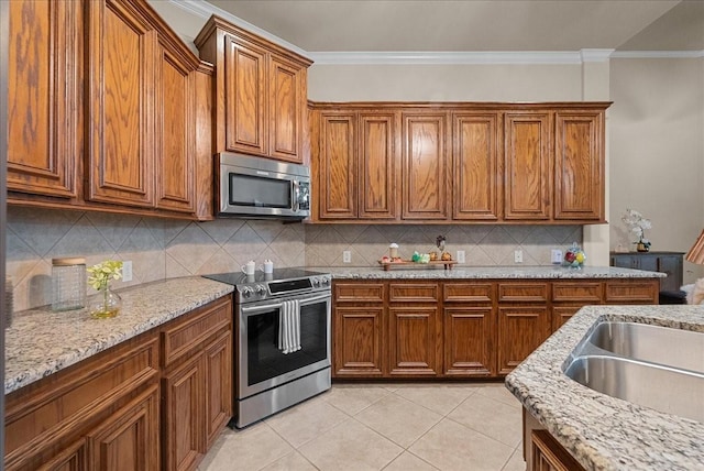 2512 Garnetfield Ln, Friendswood, TX 77546 - kitchen featuring appliances with stainless steel finishes, brown cabinetry, crown molding, tasteful backsplash, and light stone counters