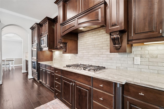 315 Lagarto Way, Pinehurst, TX 77362 - kitchen featuring arched walkways, appliances with stainless steel finishes, ornamental molding, custom range hood, and dark wood-style floors