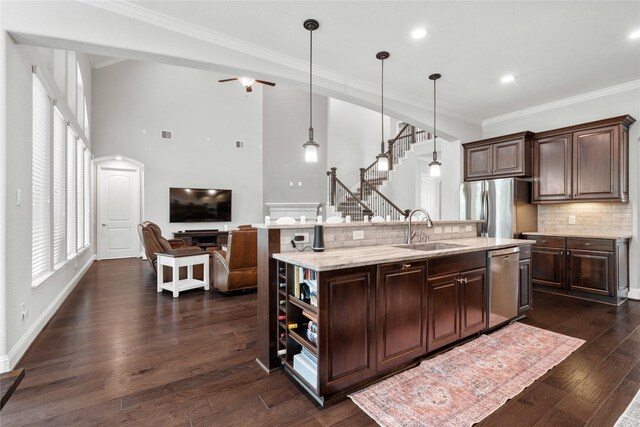315 Lagarto Way, Pinehurst, TX 77362 - kitchen featuring a sink, appliances with stainless steel finishes, ornamental molding, an island with sink, and backsplash