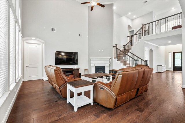 315 Lagarto Way, Pinehurst, TX 77362 - living area featuring arched walkways, a high ceiling, a fireplace, a ceiling fan, and dark wood finished floors