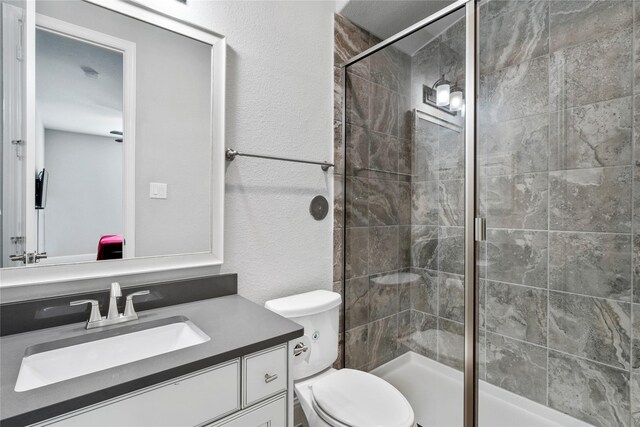 315 Lagarto Way, Pinehurst, TX 77362 - bathroom featuring vanity, a stall shower, toilet, and a textured wall