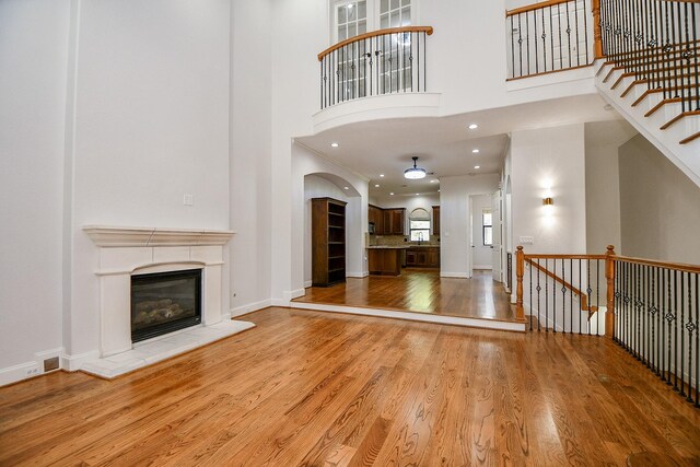 608 Westcott St, Houston, TX 77007 - unfurnished living room with a high ceiling, wood finished floors, and a glass covered fireplace