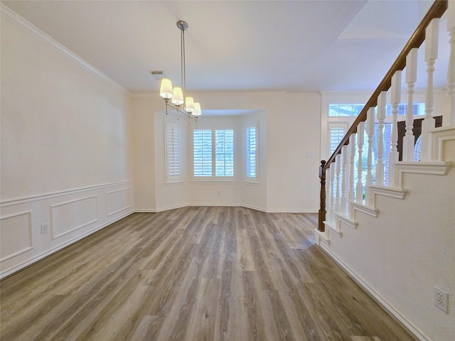 6415 Taimer Ct, Sugar Land, TX 77479 - unfurnished dining area featuring stairway, wood finished floors, ornamental molding, a chandelier, and baseboards