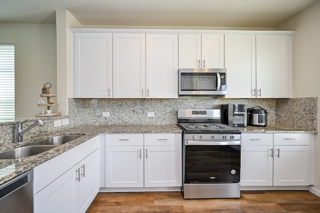 4611 Prairie Chase Dr, Houston, TX 77069 - kitchen with appliances with stainless steel finishes, a sink, backsplash, and white cabinetry