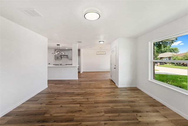 7815 Brook Trail Cir, Houston, TX 77040 - unfurnished living room featuring dark wood finished floors, baseboards, and a chandelier