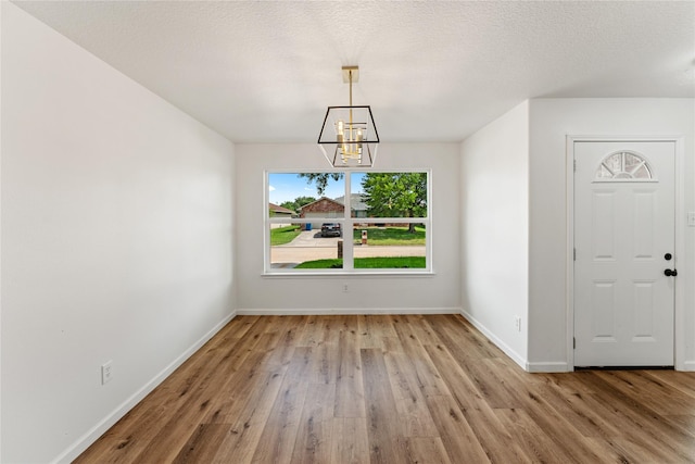 7815 Brook Trail Cir, Houston, TX 77040 - unfurnished dining area featuring a chandelier, wood finished floors, and baseboards