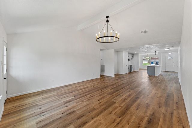 7815 Brook Trail Cir, Houston, TX 77040 - unfurnished living room featuring a chandelier, beam ceiling, a sink, light wood-style floors, and baseboards