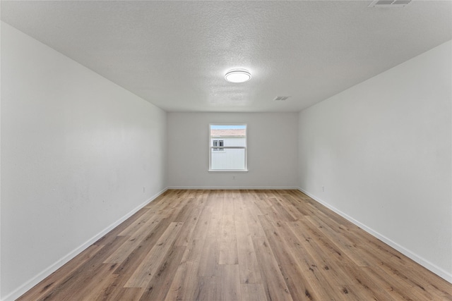 7815 Brook Trail Cir, Houston, TX 77040 - empty room featuring light wood finished floors, a textured ceiling, and baseboards