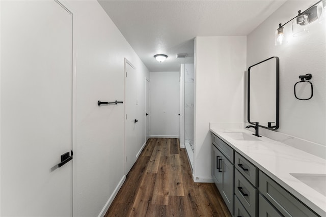 7815 Brook Trail Cir, Houston, TX 77040 - bathroom featuring wood finished floors, double vanity, baseboards, and a shower