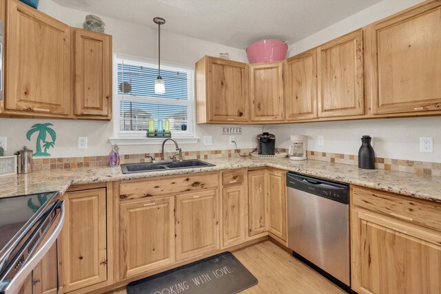123 Howard Ave, Surfside Beach, TX 77541 - kitchen with appliances with stainless steel finishes, a sink, light brown cabinetry, light wood finished floors, and light stone counters
