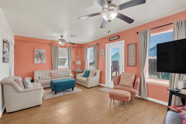 123 Howard Ave, Surfside Beach, TX 77541 - living area featuring light wood-style flooring, ceiling fan, baseboards, and healthy amount of natural light