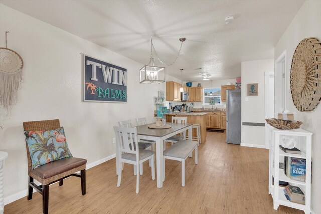 123 Howard Ave, Surfside Beach, TX 77541 - dining area with light wood finished floors, a chandelier, and baseboards