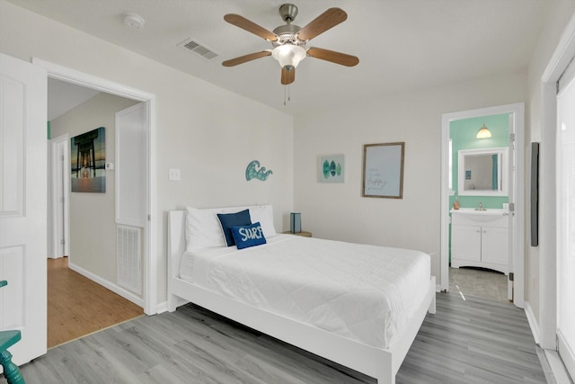 123 Howard Ave, Surfside Beach, TX 77541 - bedroom featuring wood finished floors, baseboards, ensuite bath, and ceiling fan