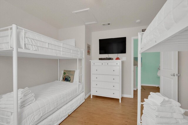 123 Howard Ave, Surfside Beach, TX 77541 - bedroom with attic access, light wood-type flooring, and baseboards