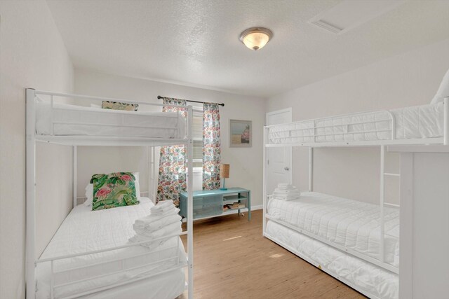 123 Howard Ave, Surfside Beach, TX 77541 - bedroom featuring wood finished floors, a textured ceiling, and baseboards