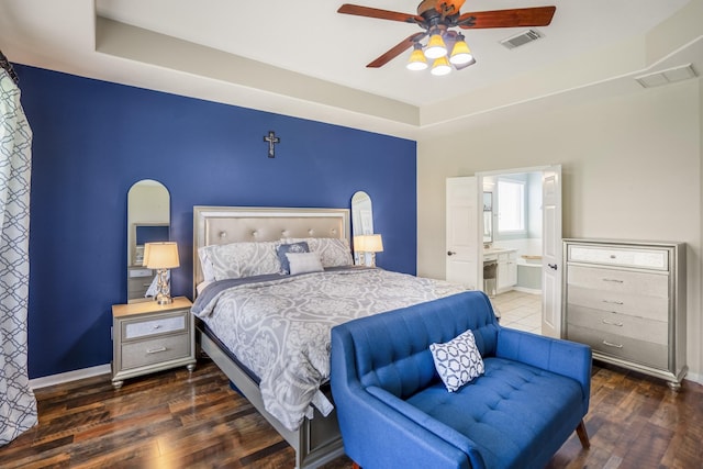 20918 Normandy Forest Dr, Spring, TX 77388 - bedroom featuring wood finished floors, ensuite bath, a tray ceiling, a ceiling fan, and baseboards