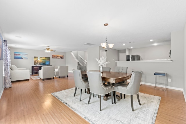 16606 Burnell Oaks Ln, Houston, TX 77090 - dining space featuring wood finished floors, a chandelier, ceiling fan, baseboards, and stairs