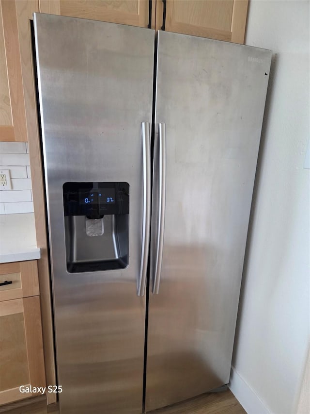 16111 Aberdeen Forest Dr, Houston, TX 77095 - detailed view of stainless steel fridge, light brown cabinets, light countertops, wood finished floors, and baseboards