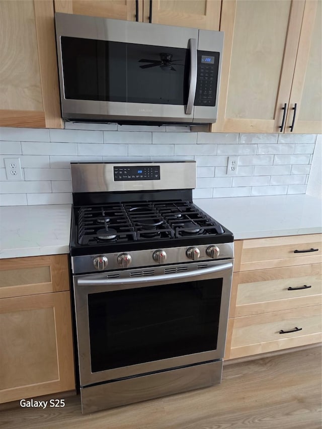 16111 Aberdeen Forest Dr, Houston, TX 77095 - kitchen with stainless steel appliances, light brown cabinets, light countertops, and light wood-type flooring