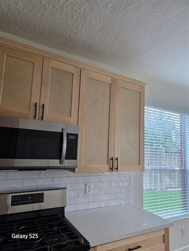 16111 Aberdeen Forest Dr, Houston, TX 77095 - kitchen featuring appliances with stainless steel finishes, light brown cabinets, tasteful backsplash, and a textured ceiling