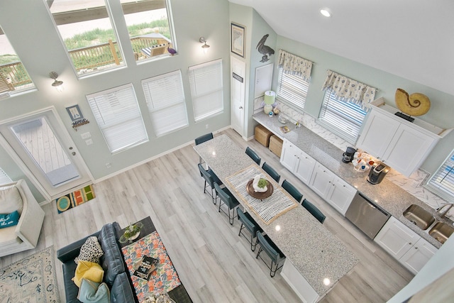 1214 Hwy 87, Gilchrist, TX 77617 - living room featuring light wood finished floors, healthy amount of natural light, a high ceiling, baseboards, and recessed lighting