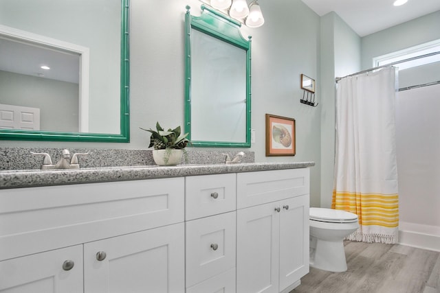 1214 Hwy 87, Gilchrist, TX 77617 - bathroom featuring double vanity, toilet, wood finished floors, curtained shower, and recessed lighting