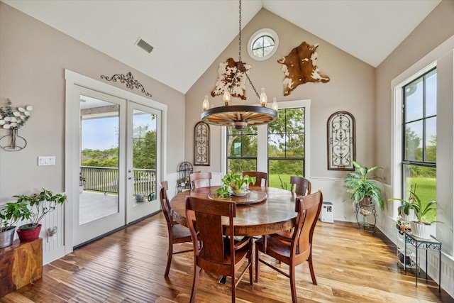 1932 Chappell Ridge Ln, Chappell Hill, TX 77426 - dining space featuring a chandelier, plenty of natural light, light wood-style flooring, a wainscoted wall, and high vaulted ceiling