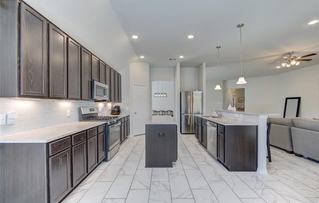 20910 Big Cypress Creek Trl, Humble, TX 77338 - kitchen featuring appliances with stainless steel finishes, a center island with sink, open floor plan, a sink, and dark brown cabinets
