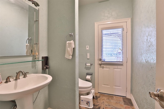 2107 N Shadow Grove Ln, Richmond, TX 77406 - bathroom with stone finish floors, toilet, and a sink
