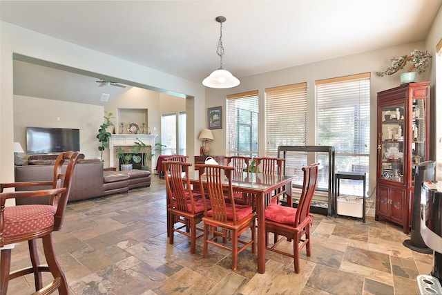 2107 N Shadow Grove Ln, Richmond, TX 77406 - dining space with stone tile floors, lofted ceiling, and a fireplace