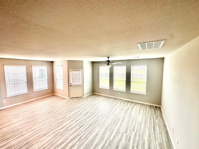 27207 Blue Pool Dr, Katy, TX 77493 - unfurnished room featuring light wood finished floors, a textured ceiling, baseboards, ceiling fan, and plenty of natural light