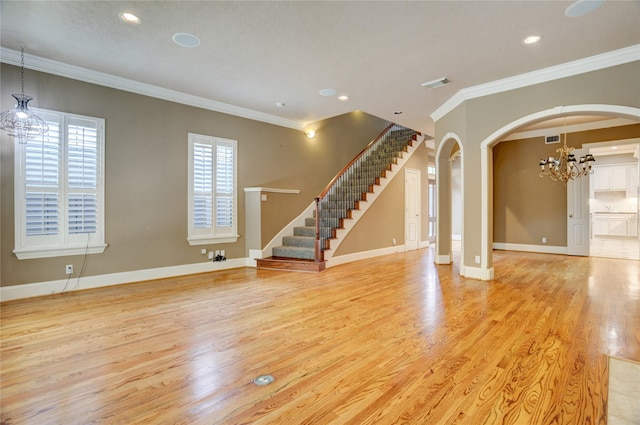 1210 Crocker St, Houston, TX 77019 - unfurnished living room featuring a chandelier, wood finished floors, ornamental molding, stairway, and arched walkways