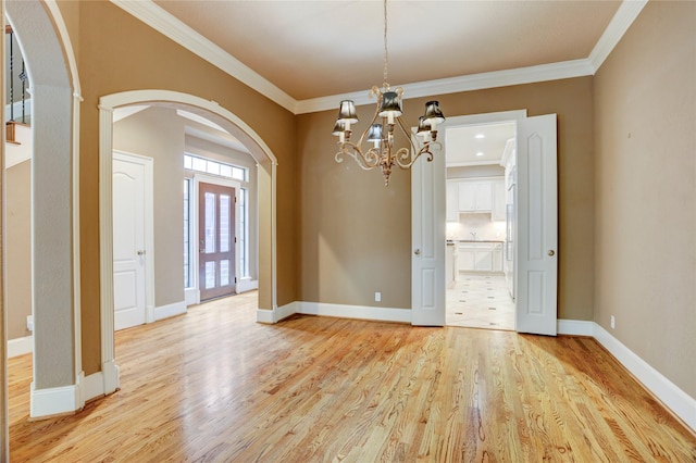 1210 Crocker St, Houston, TX 77019 - empty room with arched walkways, light wood-style floors, crown molding, and a chandelier