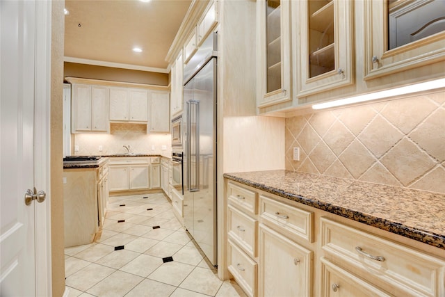 1210 Crocker St, Houston, TX 77019 - kitchen with ornamental molding, dark stone counters, built in appliances, backsplash, and light tile patterned flooring