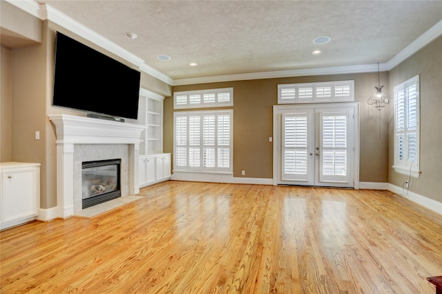 1210 Crocker St, Houston, TX 77019 - unfurnished living room with ornamental molding, a textured ceiling, a fireplace, wood finished floors, and built in shelves